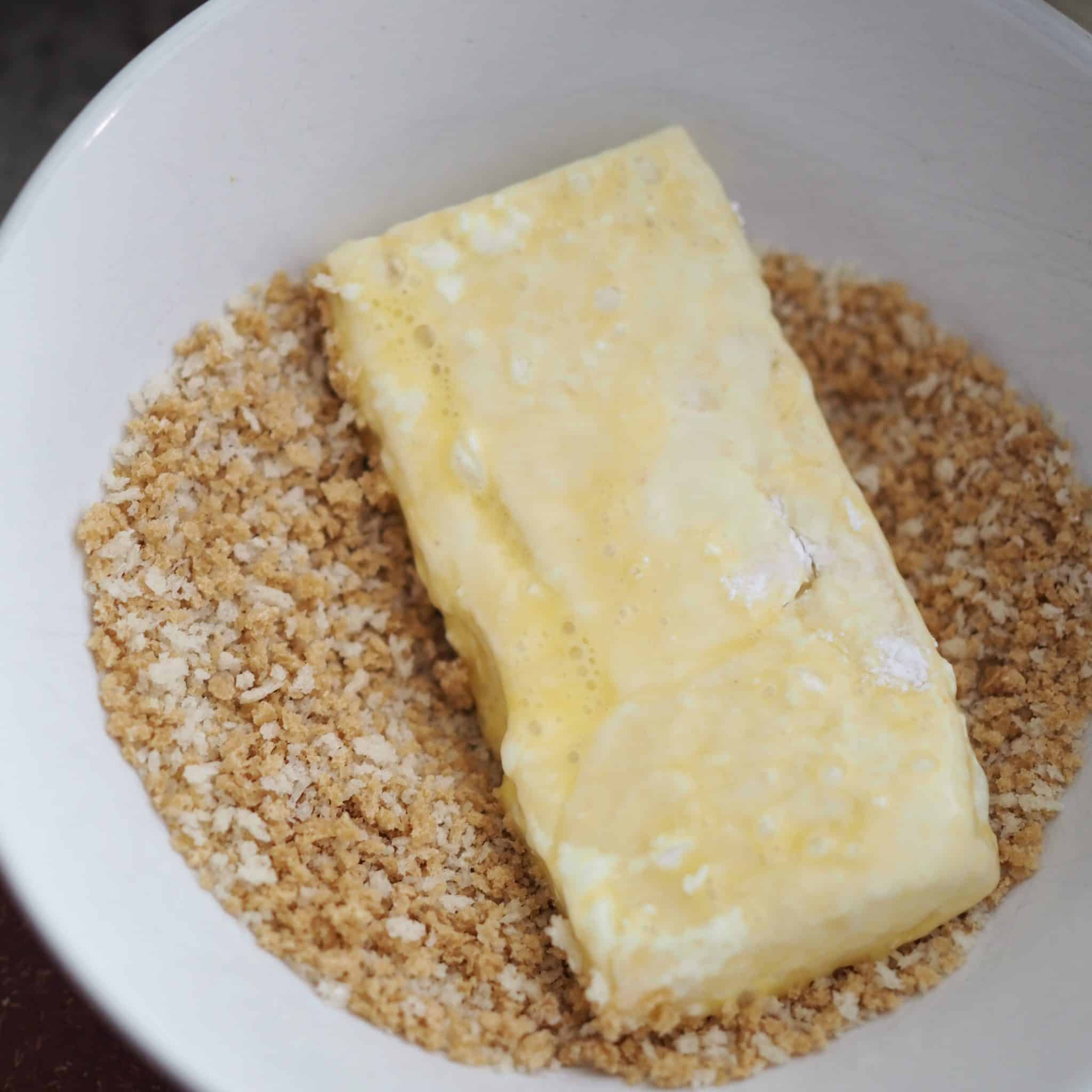 Prepare three bowls, the first containing cornstarch, the second containing beaten eggs and the third containing the breadcrumbs. Dredge the tofu into cornstarch, then eggs, and lastly breadcrumbs.