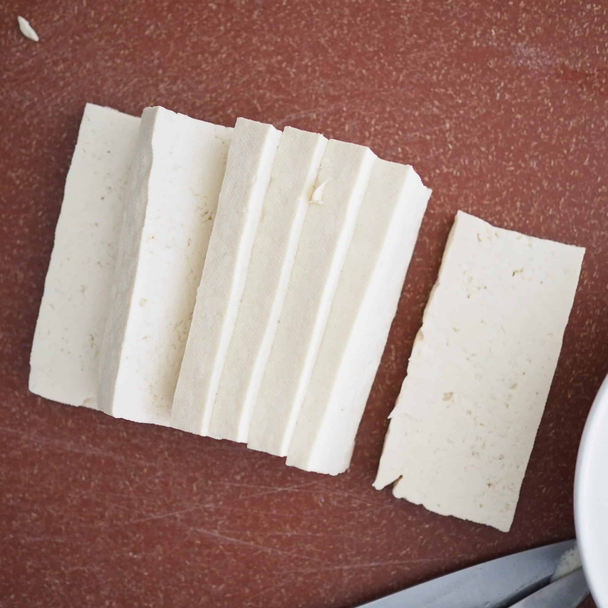 Slice the tofu vertically into 1 cm thick pieces. Pat the tofu dry with paper towel. This is important or your coating will fall off.