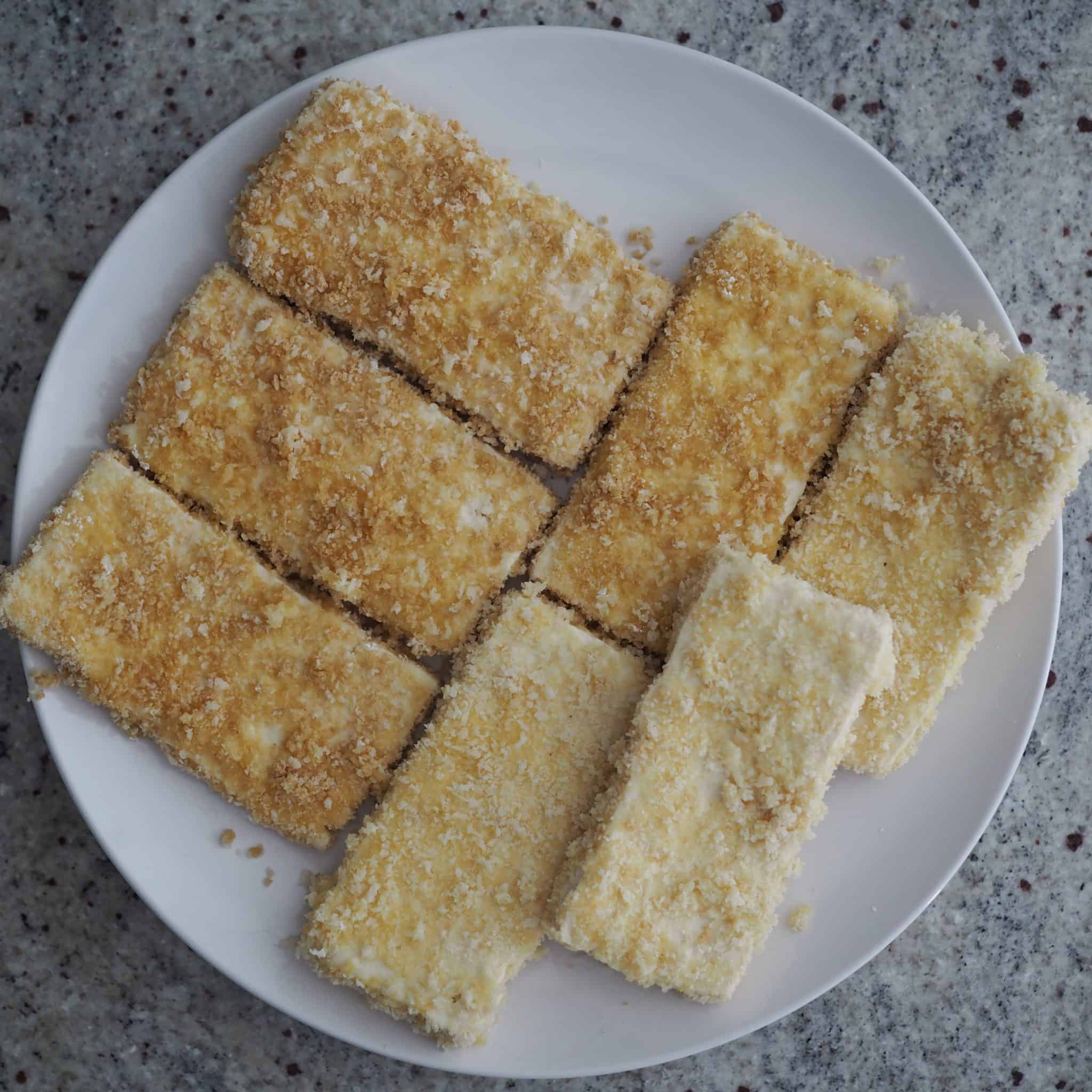 Make sure to coat the tofu on all sides, ensuring no bald spots. Transfer coated tofu to a plate.