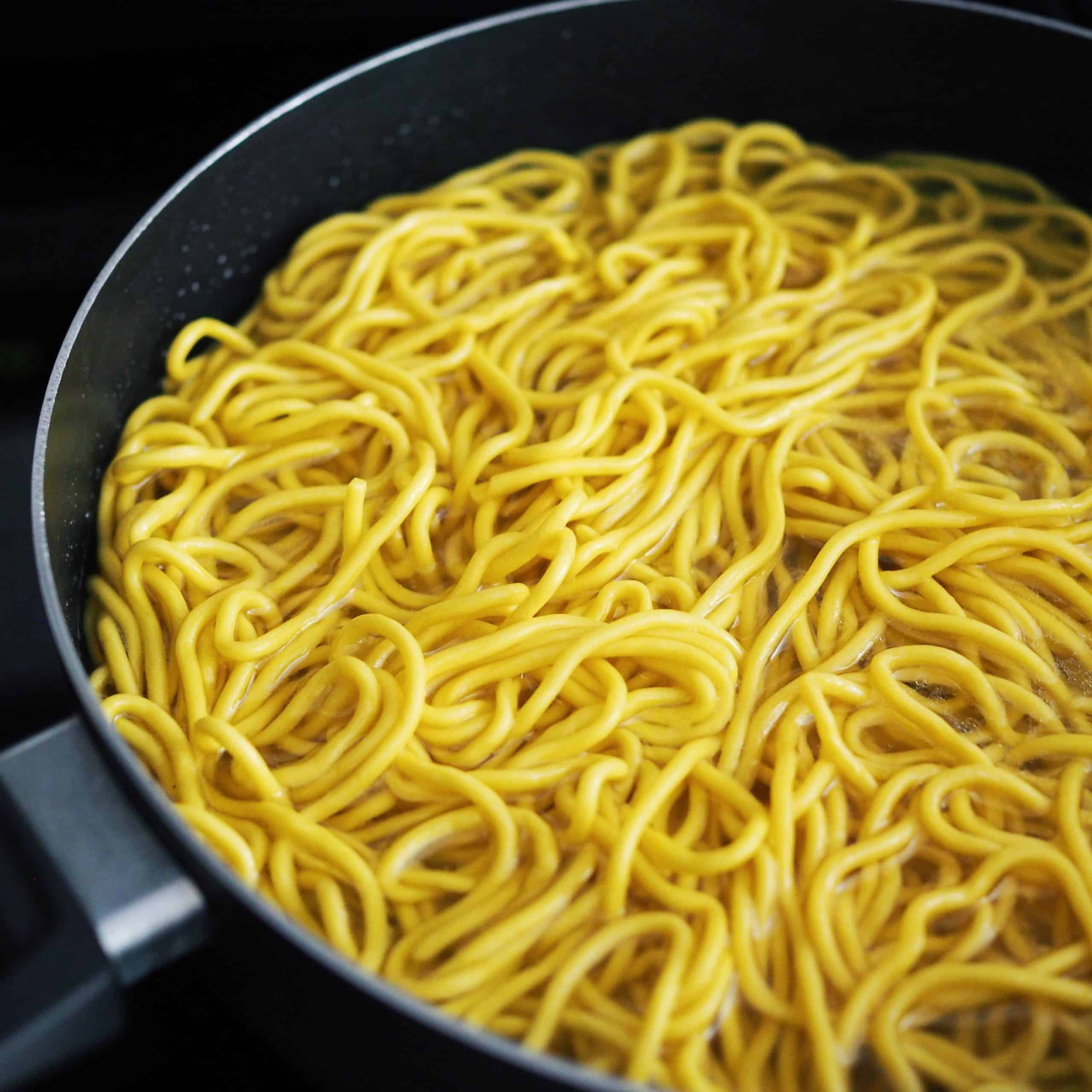 In a large pot or deep pan filled with boiling hot water, bring to boil and blanch your noodles just until loosened about 20-30 seconds and strain immediately.