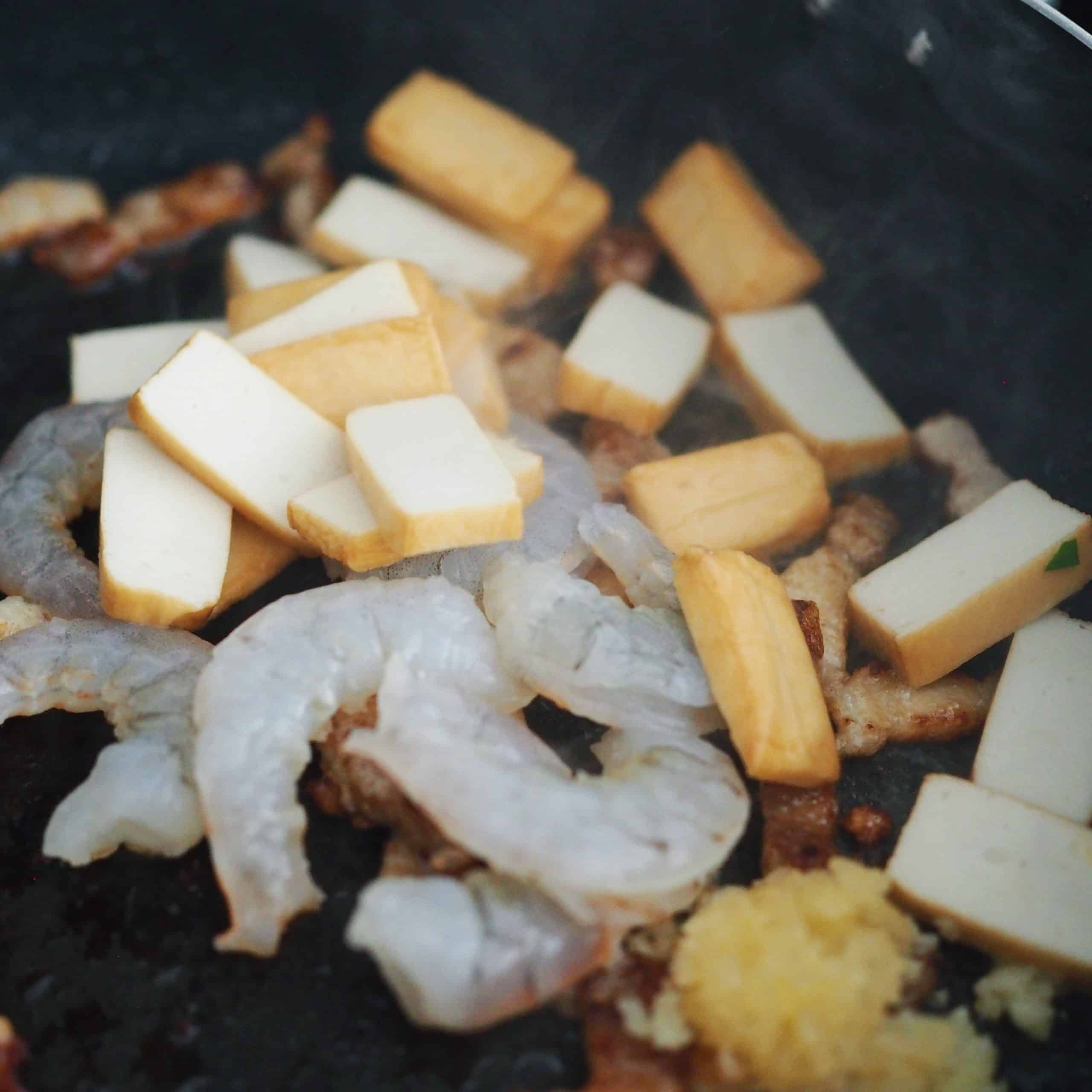 Toss in shrimp, fish cakes and cook until the shrimps become mostly pink.