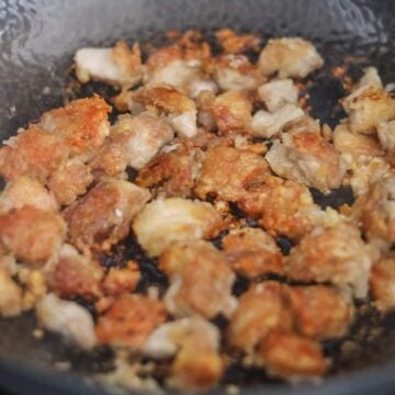 Chicken frying in a pan in small batches until golden brown, transferred to a wire rack to drain excess oil