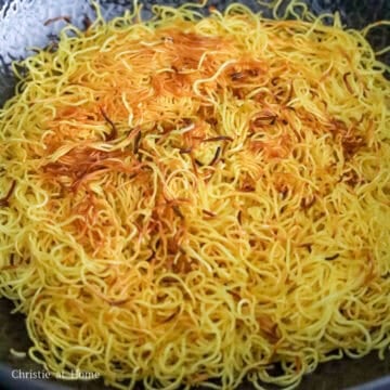 Heat ¼ cup or 60 ml of vegetable oil in a large wok or large pan on medium heat. Once the oil is hot, add noodles and spread them into a circular pancake. Fry until golden and crispy on the bottom. Rotating the pancake occasionally for an even crust.