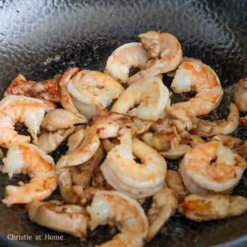 On medium heat, add 1 teaspoon or 5 ml vegetable oil and fry chicken until 50% cooked. Add shrimp and cooked until they are pink and curled. Remove and set aside.
