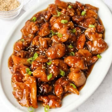 Toss in fried chicken into sauce until evenly coated. Remove off heat. Garnish with green onions and more sesame seeds. Enjoy!