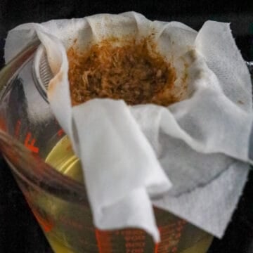 Then over very low heat, cover and simmer the broth for 5 minutes. Meanwhile, place a clean paper towel into a fine sieve and rest it over a large measuring cup or bowl. Uncover and strain out the broth through the paper towel and fine sieve. Do not strain the broth without a paper towel or a fine sieve or it won't catch all the flakes. Pour this homemade dashi broth back into the pot.