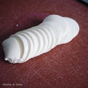 Next remove silken tofu from packaging and strain out the liquids. Transfer the tofu to a cutting board and gently slice into thin layers with a sharp knife.