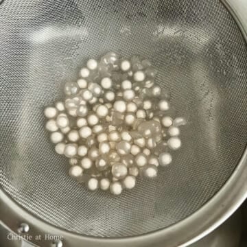 Strain the cooked pearls in a fine sieve and rinse them under cold running water to remove excess starch. Then strain out any excess water.