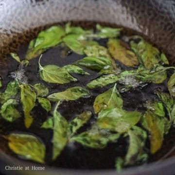 Next with fresh basil in one hand and a pan lid in the other, drop the basil into the hot oil and quickly cover to shield yourself from oil splash back. Deep fry for 10-15 seconds or until crispy.
