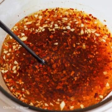 Very carefully pour the hot oil into the bowl with the red chili flakes and let it bubble. Then stir the flakes with the oil to prevent the flakes from overcooking or burning.