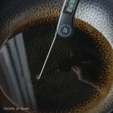 Heat vegetable oil in a large pot or wok on low-medium heat, around 250 F with a digital instant read thermometer. Or insert a wooden utensil into the hot oil and look for bubbles.