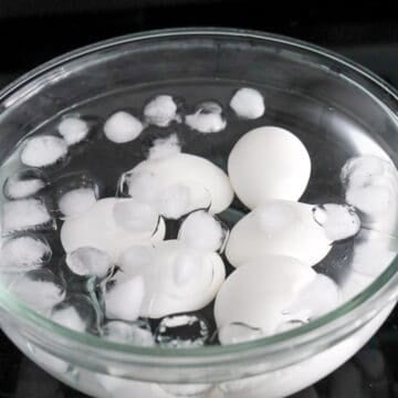 Prepare a large bowl with enough water and ice cubes. Remove the boiled eggs from boiling water with a slotted spoon and transfer them to the ice bath to cool down completely.