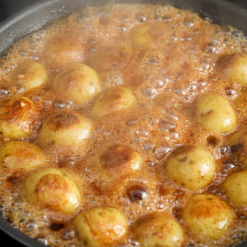 Then pour the braising sauce mixture on top of the potatoes. Gently toss potatoes into sauce for 5 minutes, until sauce has thickened slightly. Remove off heat. Serve and garnish with green onions and a drizzle of sesame oil. Enjoy!