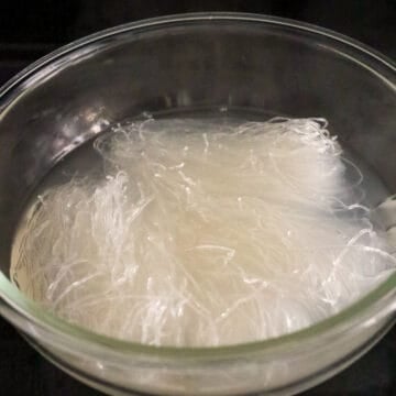 In a large bowl, soak mung bean noodles in hot boiling water for 50 seconds until softened and clear. Strain immediately shaking out as much excess water.