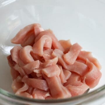 First thinly slice pork loin into 1 cm wide pieces. Transfer pork into a medium bowl.