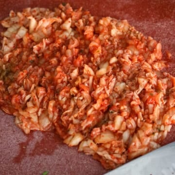 On a cutting board, finely chop kimchi. Transfer to a large mixing bowl.