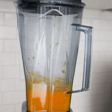 Ripe mangoes being peeled, pitted, and blended into a very smooth purée, then strained through a fine sieve for an ultra-silky texture.