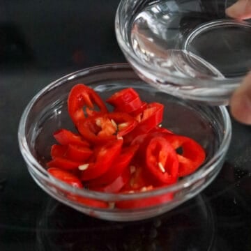 In a small bowl, combine red chili and white vinegar. Set aside.Â