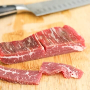 Thinly slice flank steak on a bias into ¼-inch thick pieces and transfer to a large bowl