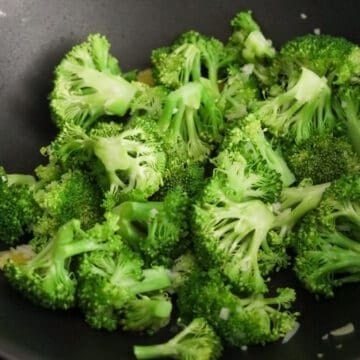 Into the pan, add ginger, garlic, and broccoli with ¼ cup or 60 ml of water. Cook until broccoli becomes vibrant green.