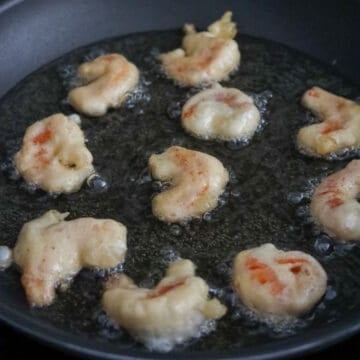 Heat vegetable oil or any neutral oil in a large pan on medium-high heat. Once it’s hot (around 350-375 degrees F), fry shrimp in small batches for 2-3 minutes until crispy and a golden brown color develops.