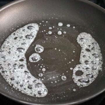 In a non-stick pan on medium heat, add sugar followed by water. Stirring constantly, bring to a simmer.