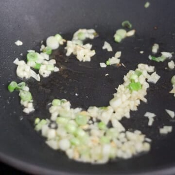 Heat oil and fry scallion whites and garlic for 10 seconds.