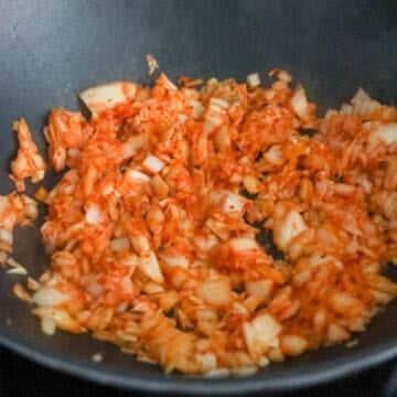 Fry in garlic, onion and chopped kimchi. Stir fry until onions are translucent and kimchi has released some of its juices, about 45-60 seconds.Â