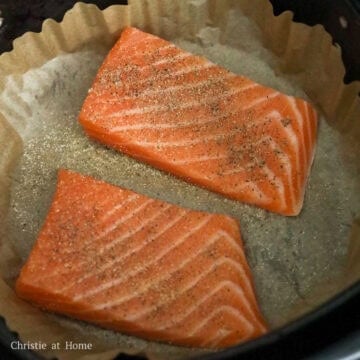 To air fry: Line the air fryer basket with air fryer parchment paper or aluminum foil. Place the salmon filets skin side down in a single layer without overlap. Evenly season the salmon with salt, black pepper and garlic powder.