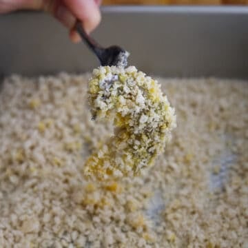 Shrimp being coated in flour, dipped in egg, and pressed into panko breadcrumbs for an even coating.