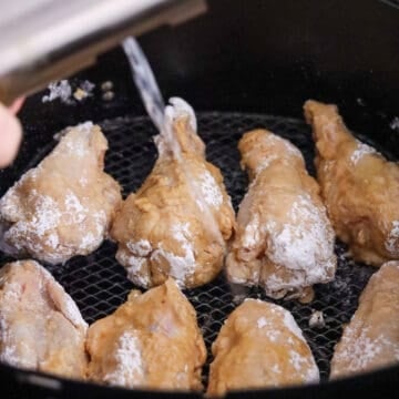 place wings in air fryer basket and spray oil on them