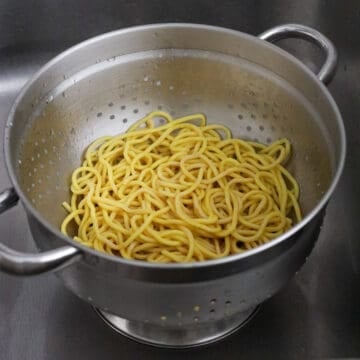 Strain noodles immediately and set aside. Do not rinse off with water.