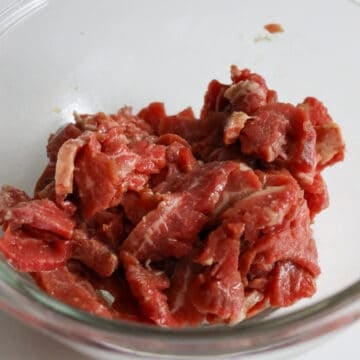 Thinly slice flank steak against the grain on an angle into ¼-inch-thick pieces and transfer beef slices to a large bowl. Add marinade ingredients as listed above to the beef and mix well. Marinate for 15-20 minutes.