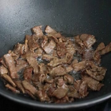 Heat vegetable oil in a large pan on medium-high heat. Fry marinated beef in a single layer until cooked and slightly browned on edges. Remove and set aside.Â