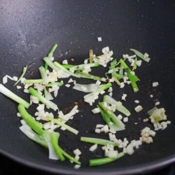 With the residual oil in the pan, fry scallion whites only and garlic for 10 seconds.Â