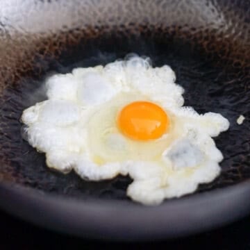 Heat vegetable oil in a non-stick pan on medium heat. Fry the egg sunny side up, over-easy or however you wish. To fry sunny side up: fry the egg until you have nearly-set whites with runny yolks while spooning some of the hot oil over the whites to set them faster.