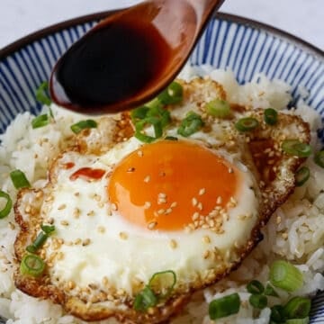 Next garnish with sesame seeds, sesame oil, chopped green onions and soy sauce and add more if desired.