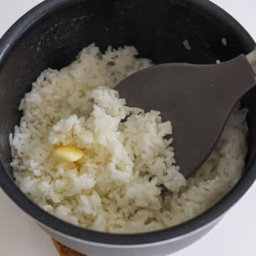 Mix hot cooked rice with butter until well combined. Transfer rice to a large bowl. (