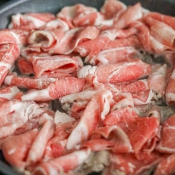 fry pork in a large pan on low medium heat until 50% cooked