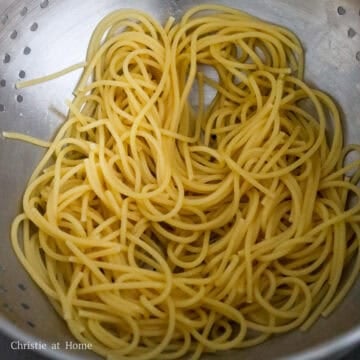 Strain cooked pasta in a colander. 