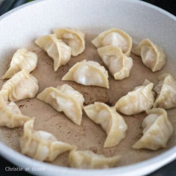 To Pan Fry: Heat 1 tablespoon or 15 ml of vegetable oil in a large pan on medium heat. Place the dumplings into the pan in small batches, about 12-15 pieces per batch, bottom side down. Let them fry for 1 minutes. Then pour about 5 mm of room temperature water into the pan, cover and cook for 12-14 minutes until the bottoms are golden brown and there are no liquids in the pan.