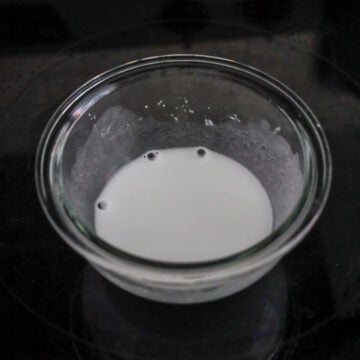A small bowl with cornstarch and water being mixed into a smooth slurry.
