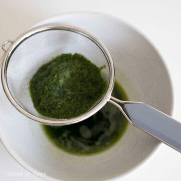 Preheat the oven to 325F/160C. Grease a 8" x 8" square cake pan. Then in a blender or food processor, add chopped pandan leaves with ¼ cup or 60 ml cold water. Blend on high until smooth. Run the pandan liquid through a fine sieve to remove the pulp to discard. Reserve this pandan extract for later.