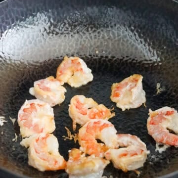 Empty the pan of the blanching water and dry it. Heat 2 teaspoon or 10 ml vegetable oil on medium heat. With tongs, transfer each piece of shrimp into the pan in a single layer (do not just pour the bowl of shrimp with the marinade into the pan or it'll create crispy bits). Fry shrimp until 85% cooked so it's slightly curled and pink, about 1-1.5 minutes in total. Do not over cook. Remove and set aside.