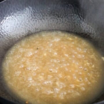 Reduce to low heat, add remaining vegetable oil with garlic and ginger into the pan. Fry for 10 seconds. Pour in stir-fry sauce and raise to medium-high heat. Simmer the sauce for 2-4 minutes until thickened.