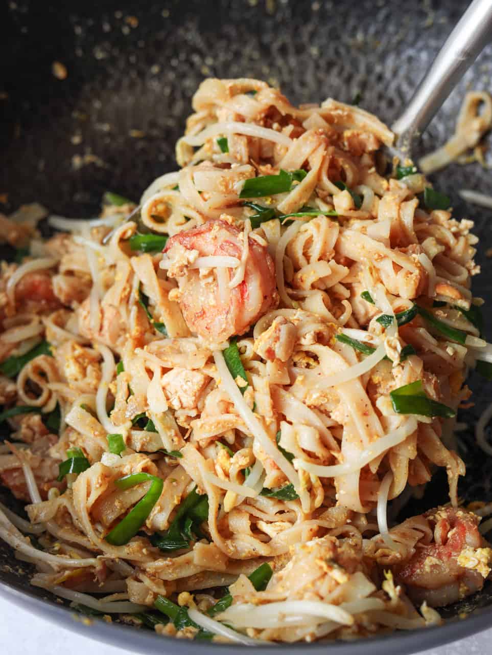 Toss in bean sprouts and garlic chives for 10-20 seconds. Remove off heat. Do not overcook them as they will wilt with the residual heat anyway. Optional: serve with limes and crushed peanuts. Enjoy!