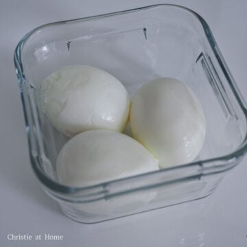 Carefully crack and peel your eggs with the back of a spoon. Place them into a small deep container or mason jar.