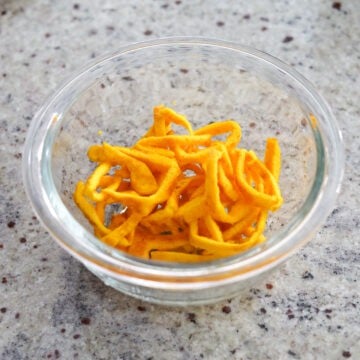 Transfer egg yolk pancake to a cutting board. Roll up the pancake and slice thinly. Repeat the same with egg white pancake.