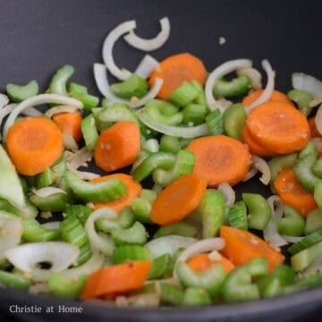 Reduce to medium heat and add remaining oil into the pan. Then add onions, garlic, carrots and celery and fry until veggies are slightly softened but still crisp, about 1-2 minutes.