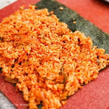 Place a sheet of nori rough side up horizontally on a clean working surface. Evenly spread 1 cup of the warm kimchi fried rice leaving a 1.5 inch-wide border.